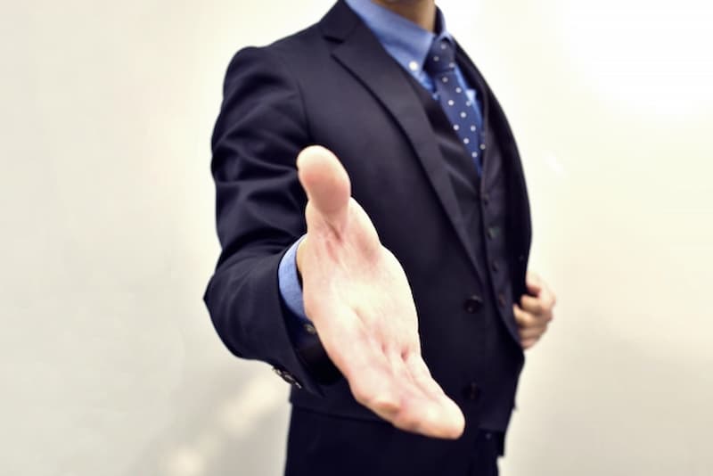 握手を求めるスーツの男性